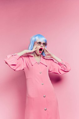 Mavi peruklu şık bir kadın. Pembe elbiseli. Kırmızı dudaklı.