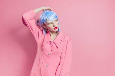Mavi peruklu şık bir kadın. Pembe elbiseli, kırmızı dudaklı, stüdyo modeli.