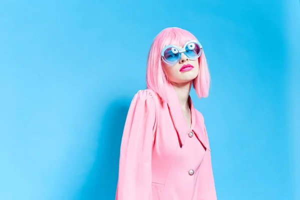 Woman in pink wig and dress on blue background — Stok fotoğraf