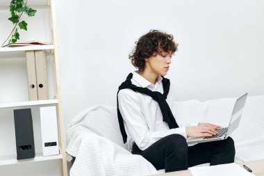 Adam dizüstü bilgisayarı beyaz koltukta oturuyor çevrimiçi yaşam tarzı eğitimi alıyor.