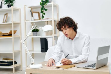 curly guy on a white sofa in front of a laptop learning communication