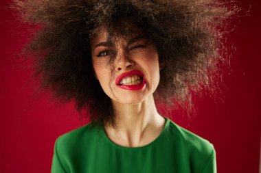 Pretty young female Afro hairstyle green dress emotions close-up studio model unaltered