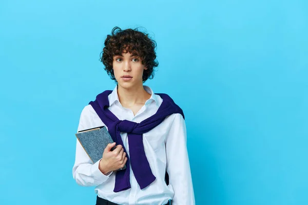 Curly guy with a book college learning jacket blue background — Φωτογραφία Αρχείου