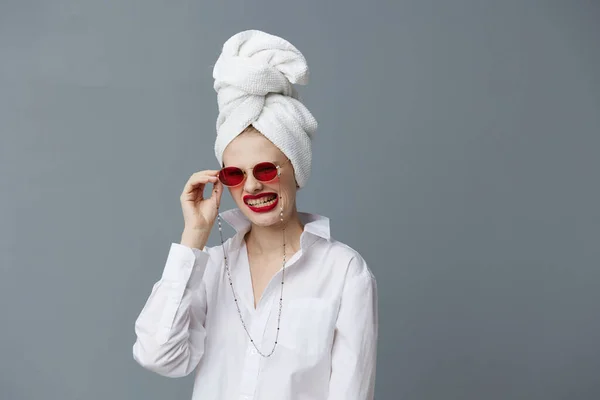 Mujer glamorosa gafas de sol rojas cosméticos con toalla en la cabeza Fondo gris — Foto de Stock