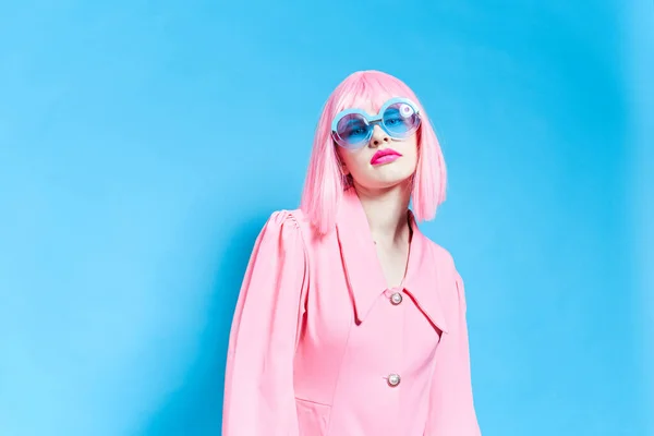 Woman in pink wig and dress on blue background — Stok fotoğraf