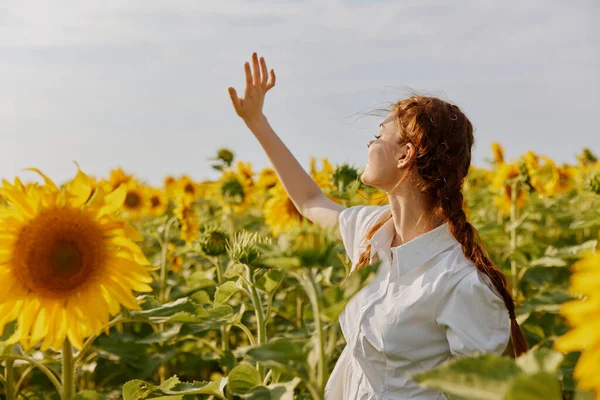 Donna con le trecce In un campo con girasoli in fiore paesaggio — Foto Stock