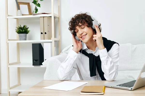 Teenager doing homework with headphones at the table Lifestyle technology — Stockfoto