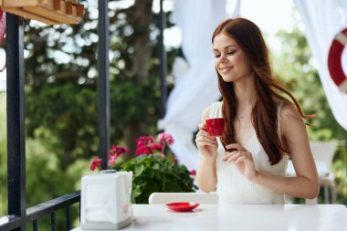 Açık havada kahve içen şık bir kadın, değişmemiş.