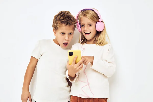 Obrázek chlapce a dívky usmívá s telefonem v ruce módní izolované pozadí — Stock fotografie