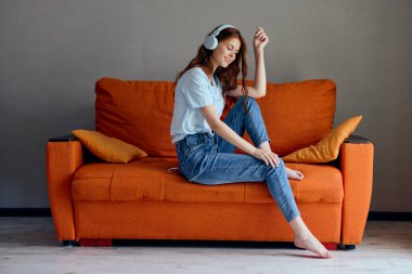 beautiful woman headphone at home on the couch entertainment technologies