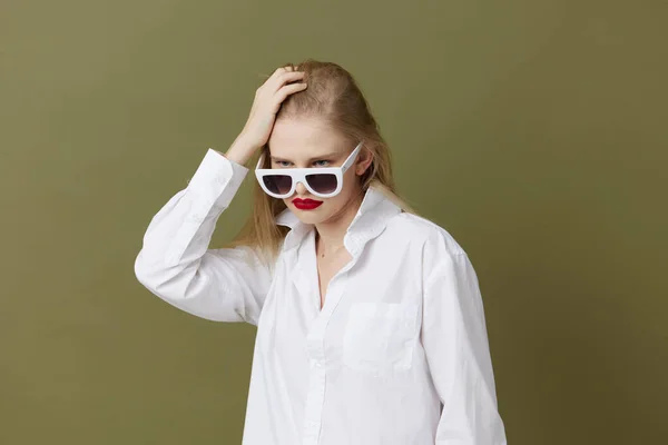 Portrait of a woman fashion white shirt sunglasses green background — Stockfoto