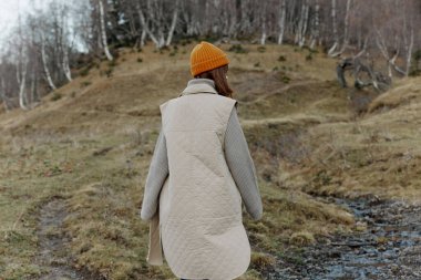 Sonbahar elbiseli kadın doğa ağaçları manzarayı gezer.