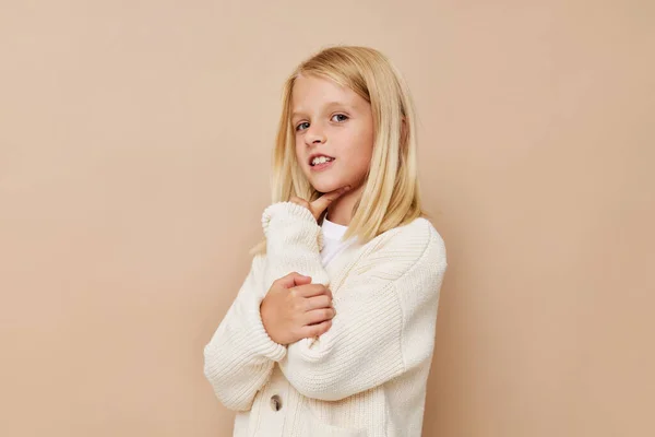 穿着毛衣的可爱小女孩，对孩子们的生活方式抱着鬼脸 — 图库照片