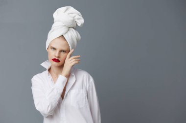 Başında havluyla beyaz gömlekli çekici bir kadın. Stüdyo modeli değiştirilmemiş.