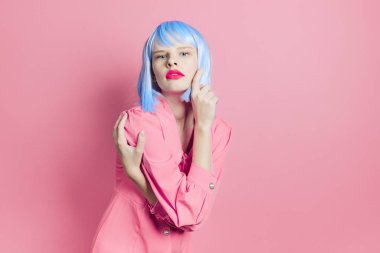 Mavi peruklu şık bir kadın. Pembe elbiseli, kırmızı dudaklı, stüdyo modeli.