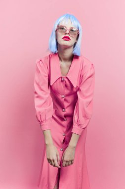 Güneş gözlüklü kadın mavi peruk takıyor pembe arka plan