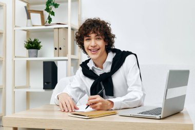 Adam dizüstü bilgisayarı beyaz koltukta oturuyor online eğitim iletişimi