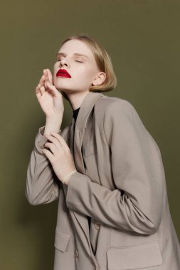 fashionable woman with red lips holds hand near face Lifestyle posing