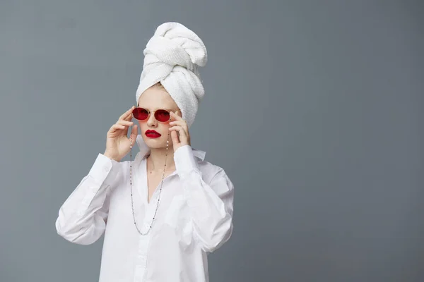 ファッショナブルな女性の赤いサングラスの化粧品とタオルの頭の隔離された背景 — ストック写真