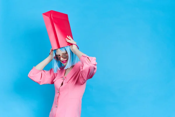 Woman in wig posing red package on her head — Stok fotoğraf