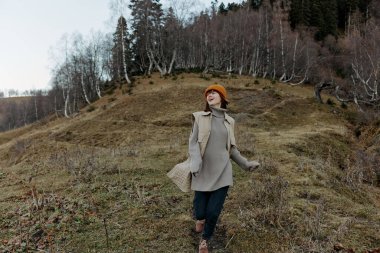 Genç kadın sonbahar havası dağlarında rahatlamak için dışarı çıkıyor.