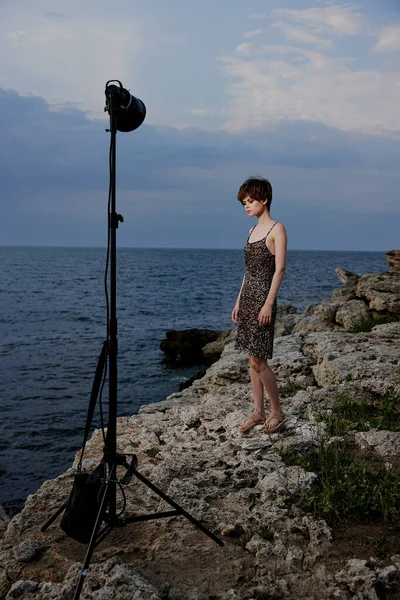 Beautiful woman standing on stones posing in beach dress luxury unaltered — Fotografia de Stock