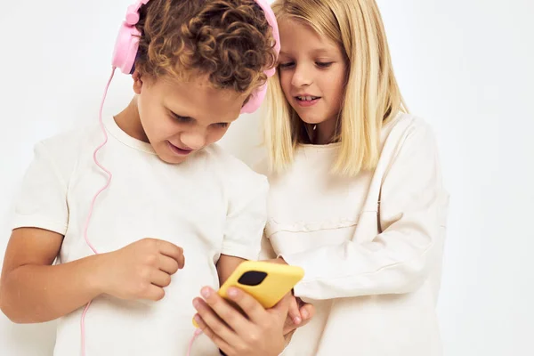 Image of boy and girl with yellow pink headphones lifestyle childhood — Stock fotografie