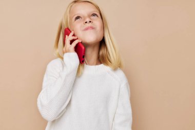 Beautiful little girl talking on the phone technology posing studio