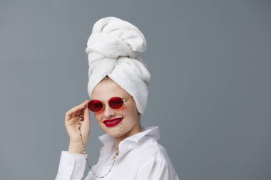 portrait of a woman red glasses towel on head makeup isolated background