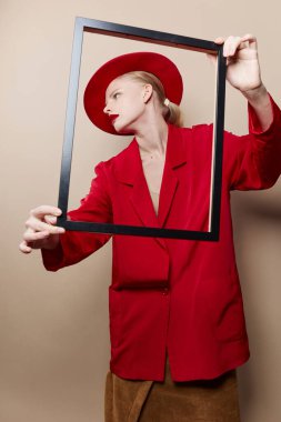 pretty woman frame in hand in red hat and jacket isolated background