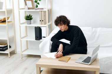 curly guy on a white sofa in front of a laptop learning communication