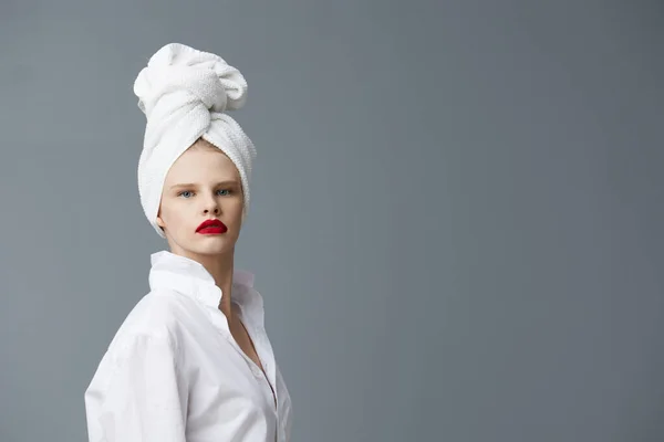 Όμορφη γυναίκα με μια πετσέτα στο κεφάλι του σε ένα λευκό πουκάμισο απομονωμένη φόντο — Φωτογραφία Αρχείου