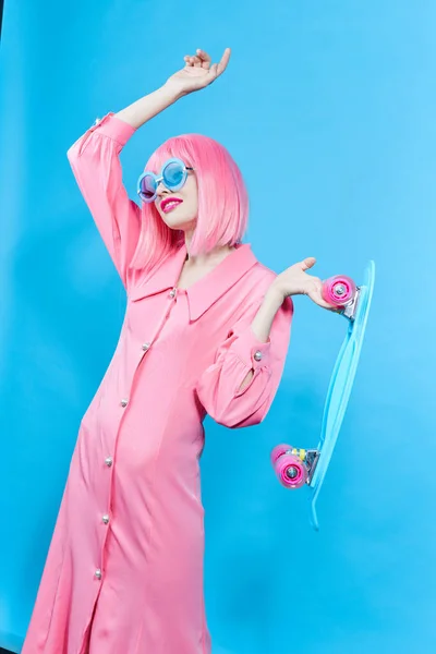 Pretty woman with skateboard in pink wig studio model unaltered — Stok fotoğraf