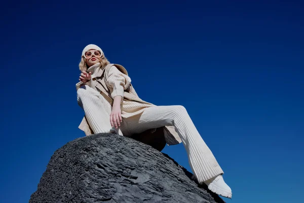 Mujer en ropa de otoño se encuentra en un paisaje de roca cielo azul relajación —  Fotos de Stock