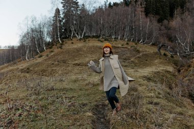 Sonbahar elbiseli kadın doğa ağaçları manzarayı gezer.