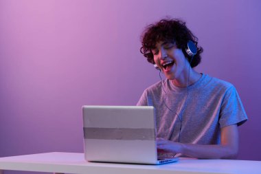 Kulaklıklı adam dizüstü bilgisayarlı eğlence dünyasının önünde yaşam tarzı teknolojisi