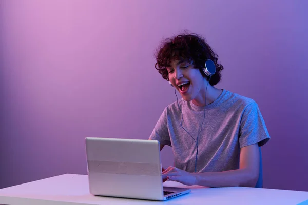 Σγουρός τύπος με ακουστικά μπροστά από την ψυχαγωγία laptop Lifestyle τεχνολογία — Φωτογραφία Αρχείου