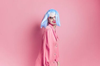 glamorous woman wearing a blue wig psing on  isolated background. High quality photo