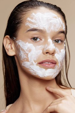 Young Woman with  face mask on beige background. High quality photo