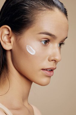 portrait of  woman with moisturizer on face on  isolated background. High quality photo