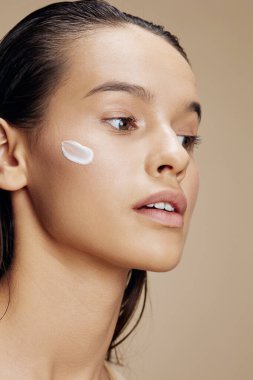 portrait of  woman with moisturizer on face on  isolated background. High quality photo