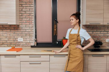 a housewife in a brown apron on  kitchen interior at home. High quality photo