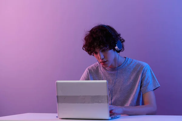 Cara ciberespaço jogar com fones de ouvido na frente de um laptop isolado fundo — Fotografia de Stock
