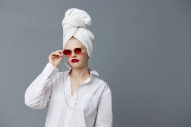Kafasında havluyla beyaz gömlekli güzel bir kadın. Stüdyo modeli değiştirilmemiş.