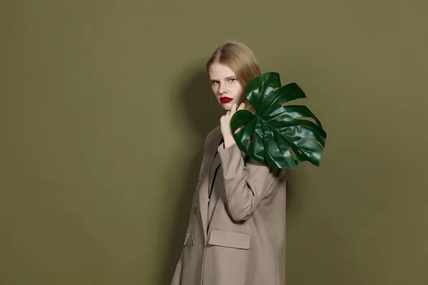 Μοντέρνα γυναίκα πράσινο παλτό φύλλο παλάμη φωτεινό μοντέλο στούντιο μακιγιάζ αμετάβλητη — Φωτογραφία Αρχείου