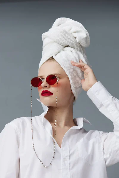 グラマラスな女性の赤いサングラスの化粧品とタオルの頭の隔離された背景 — ストック写真