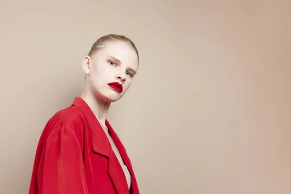 Retrato de uma mulher lábios vermelhos jaqueta de moda fundo bege — Fotografia de Stock