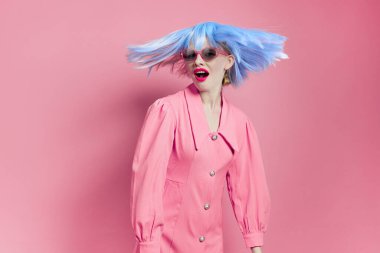 Mavi peruklu bir kadının portresi. Pembe elbise, kırmızı dudaklar, pembe arka plan.