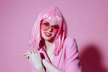 Çekici bir bayan portresi. Pembe takım elbise. Güneş gözlükleri. Renk arkaplanı değişmemiş.