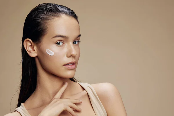 Bela mulher creme na bochecha posando cosméticos para limpar a pele close-up make-up — Fotografia de Stock